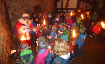 Nikolaus kommt winkend auf einem Mofa